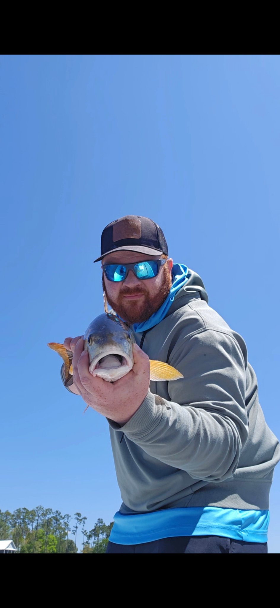 Captain Josh Gray holding a redfish